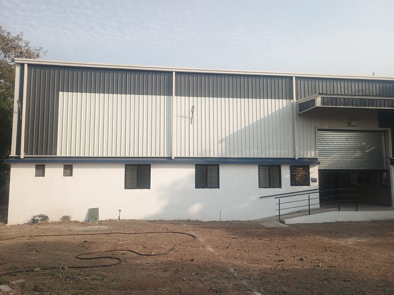 Completed PEB warehouse facility with blue and white cladding built by Swarup Enterprises